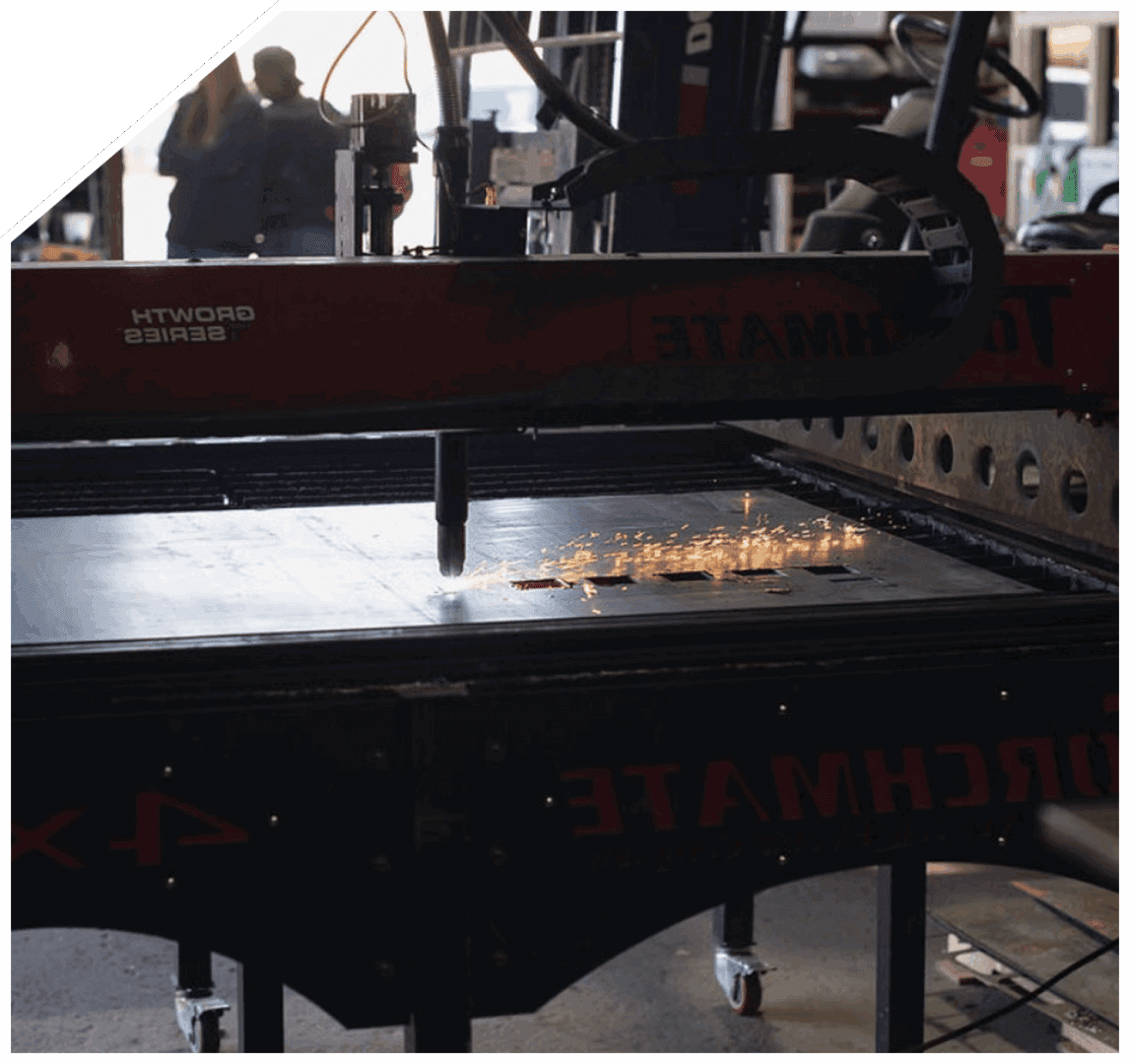 Machine cutting metal with sparks flying.